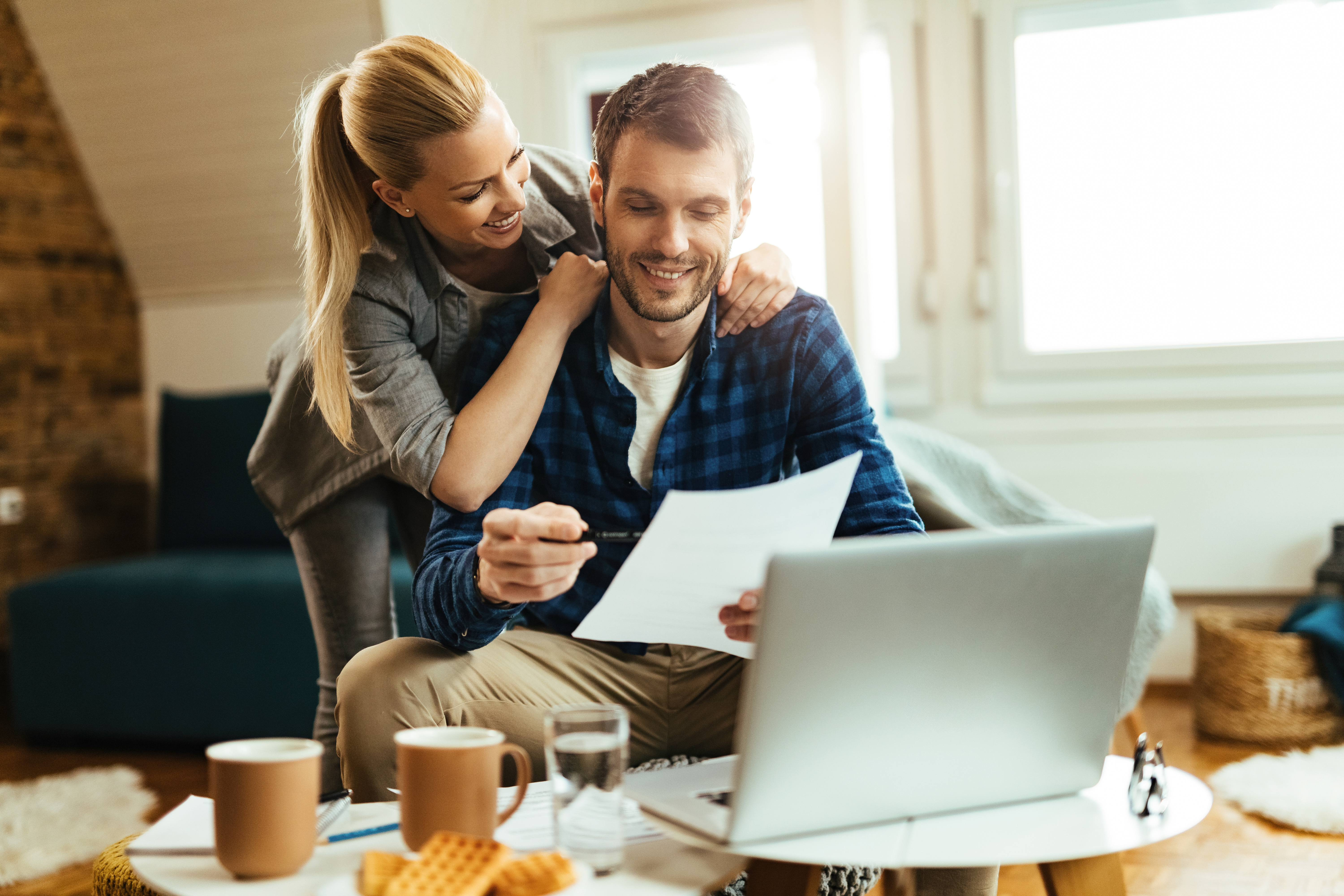 Happy couple analyzing their home budget while paying bill on a computer