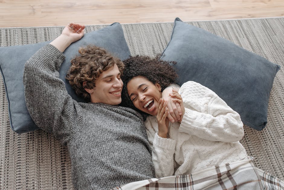 A happy couple snuggling on a cozy indoor setting, enjoying a relaxed winter day.
